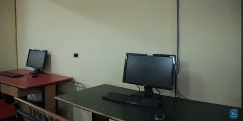 Two computer monitors on desks in a quiet lab